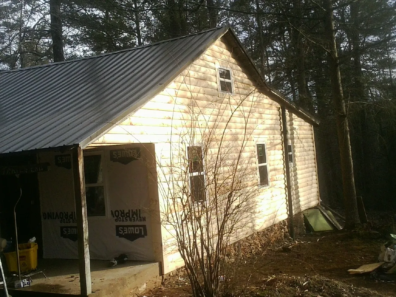 Log siding gable end under a dark metal roof edge in Saint Joseph